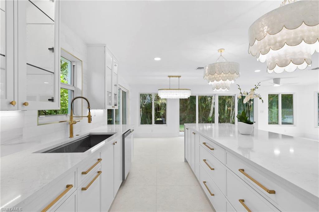17 Knights Bridge Road Naples, FL 34112 - Photo 7 of 18 a large white kitchen with granite countertop a large window and a sink