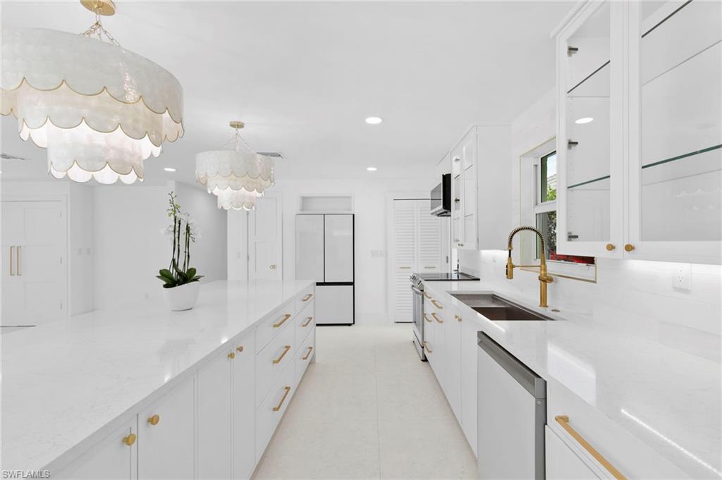 17 Knights Bridge Road Naples, FL 34112 - Photo 8 of 18 a large white kitchen with lots of counter space and sink