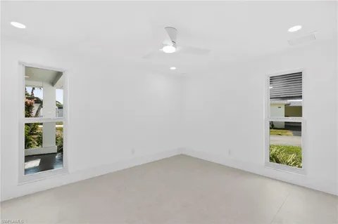 an empty room with closet and windows