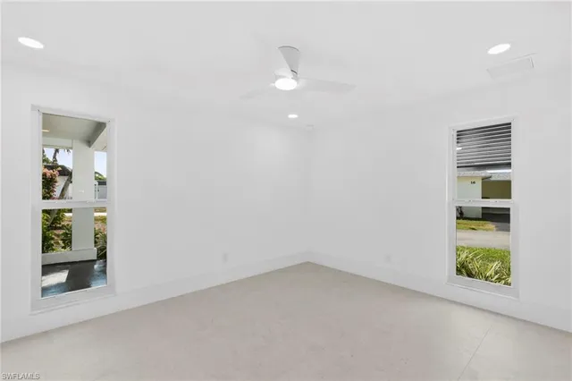 an empty room with closet and windows