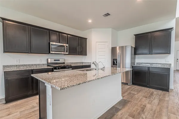 a kitchen with stainless steel appliances granite countertop a sink stove and refrigerator