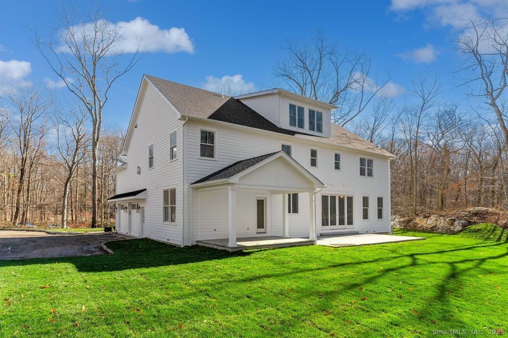 109 Signal Hill Road Wilton, CT 06897 - Photo 16 of 18 a view of a white house with a big yard and large trees