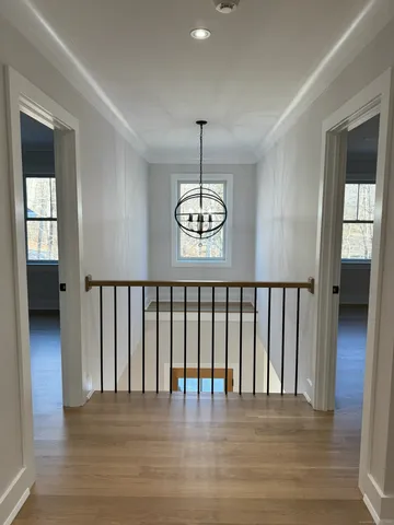 a view of a hallway with wooden floor and stairs