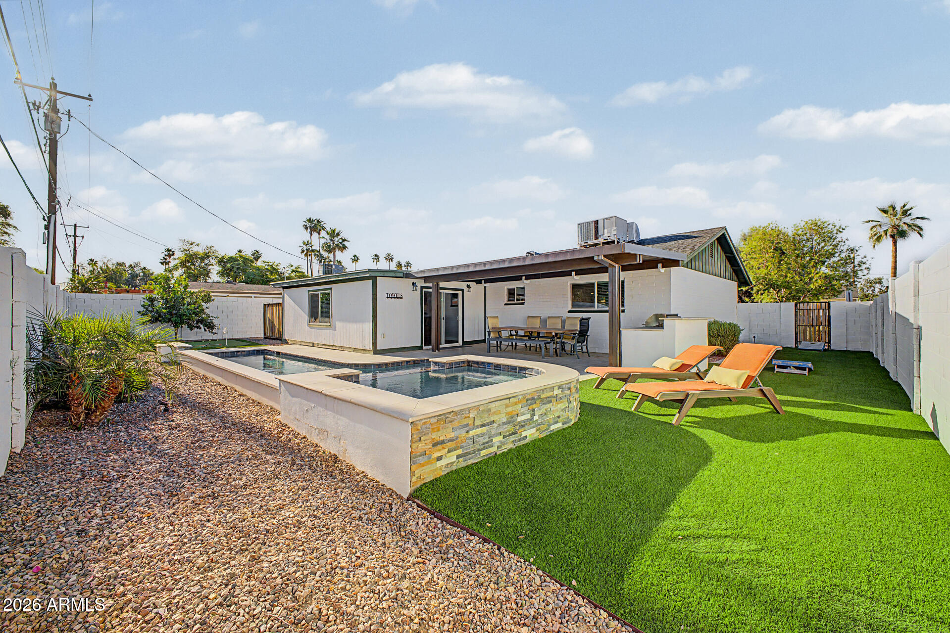 955 East Marigold Lane Tempe, AZ 85288 - Photo 28 of 32 a view of a white house with a big yard potted plants and a bench