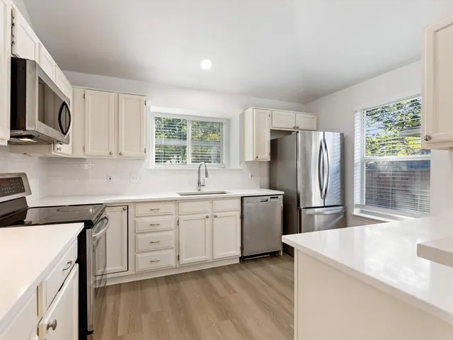 a kitchen with stainless steel appliances white cabinets and a sink