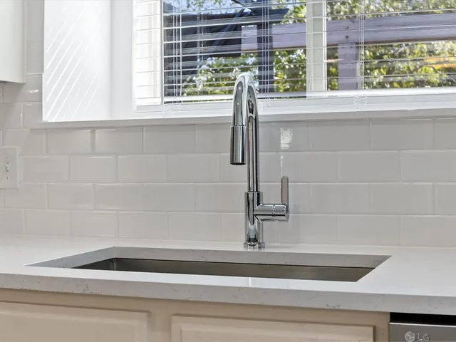 a kitchen with stainless steel appliances granite countertop a refrigerator a stove a sink a center island and cabinets