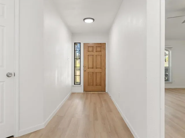a view of a hallway with wooden floor