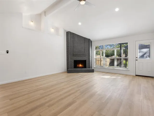 an empty room with wooden floor and fireplace