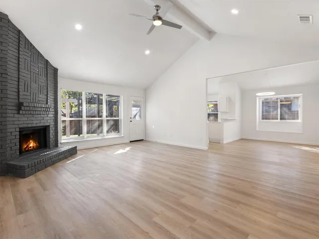 an empty room with windows and a fireplace