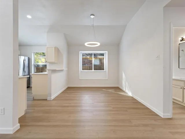 a view of a kitchen with wooden floor and a window