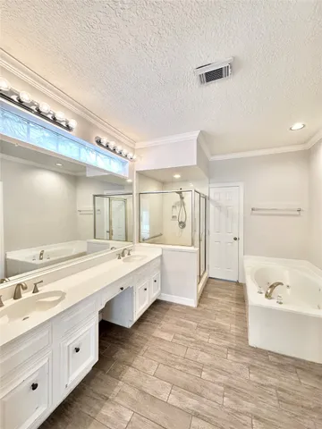 a large bathroom with a tub sink shower and mirror