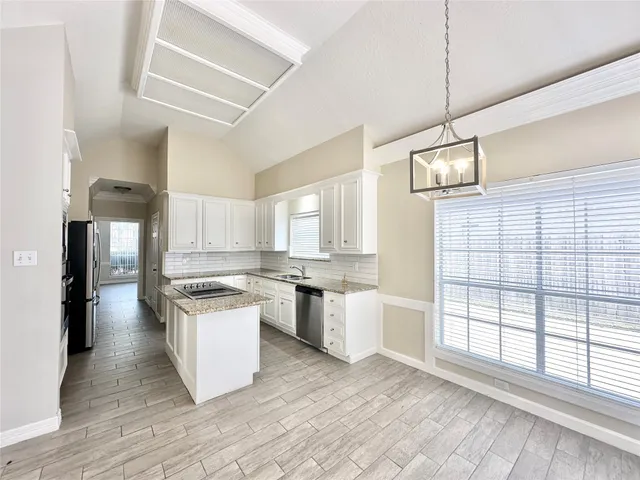 a kitchen with stainless steel appliances granite countertop a stove a sink dishwasher and a refrigerator