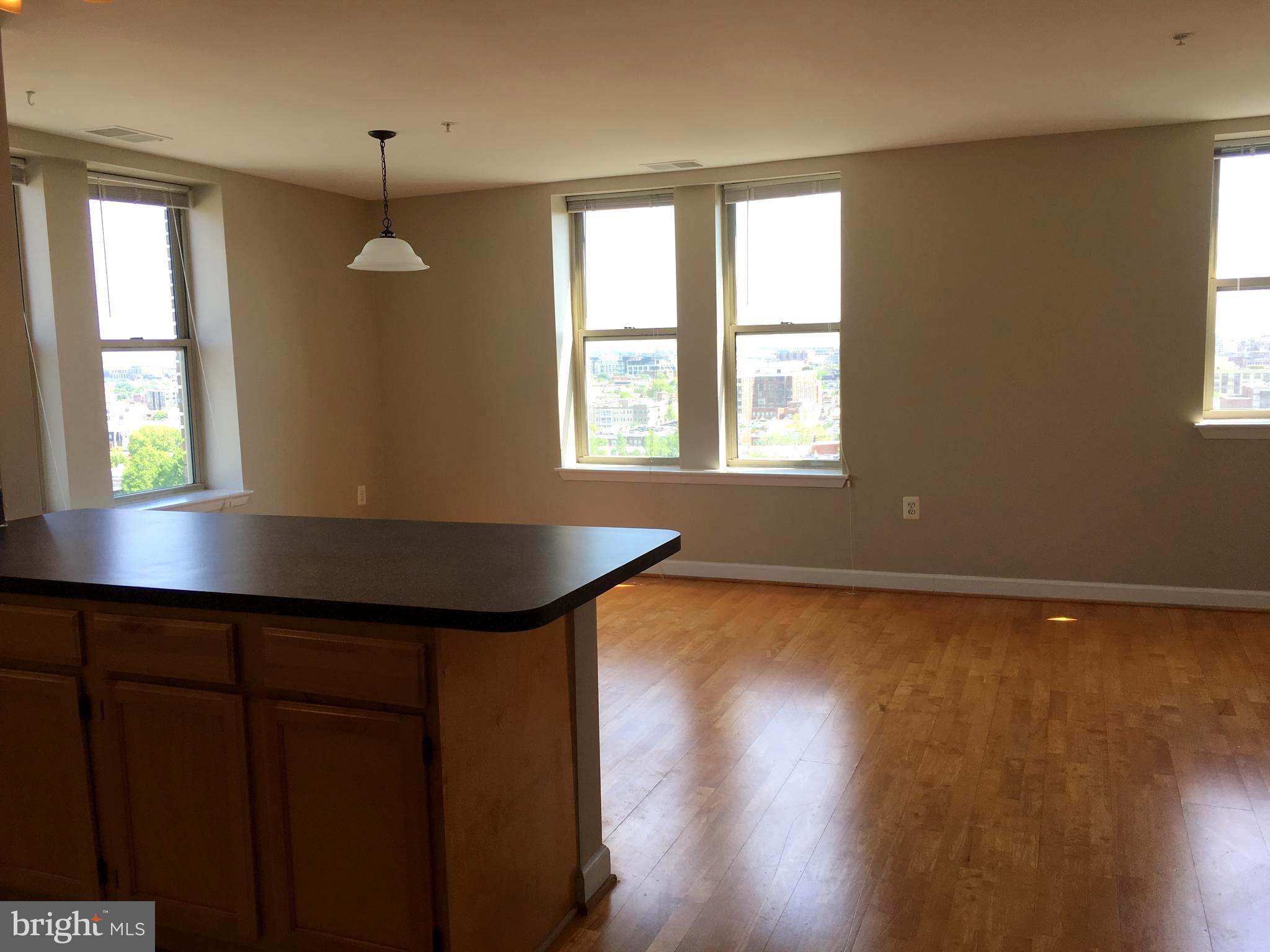 1308 Clifton Street Northwest, Unit 404 Washington, DC 20009 - Photo 4 of 14 a view of an empty room with wooden floor and a window
