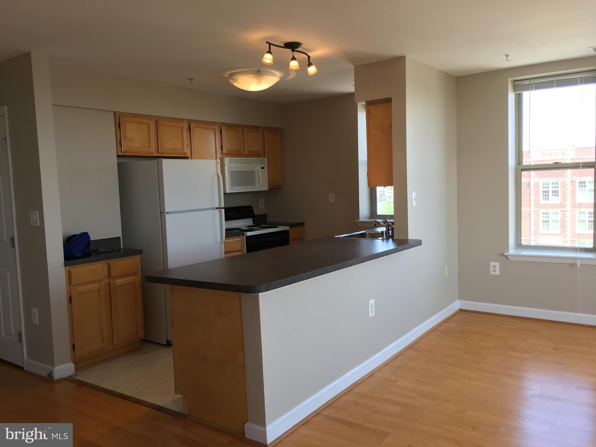 1308 Clifton Street Northwest, Unit 404 Washington, DC 20009 - Photo 5 of 14 a kitchen with stainless steel appliances a refrigerator and a stove