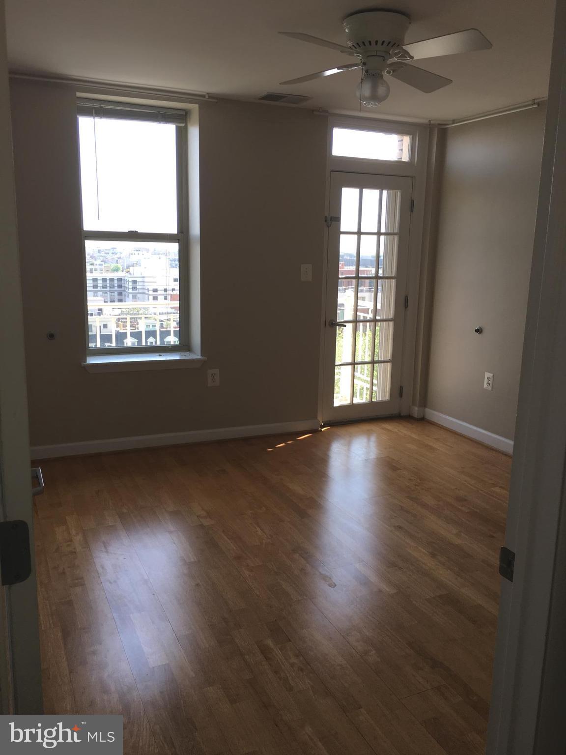 1308 Clifton Street Northwest, Unit 404 Washington, DC 20009 - Photo 8 of 14 an empty room with wooden floor and windows