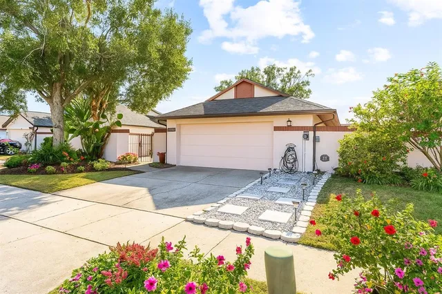 a front view of a house with a yard and a garden