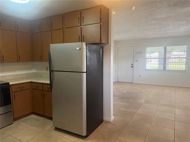 a kitchen with a refrigerator and a stove top oven
