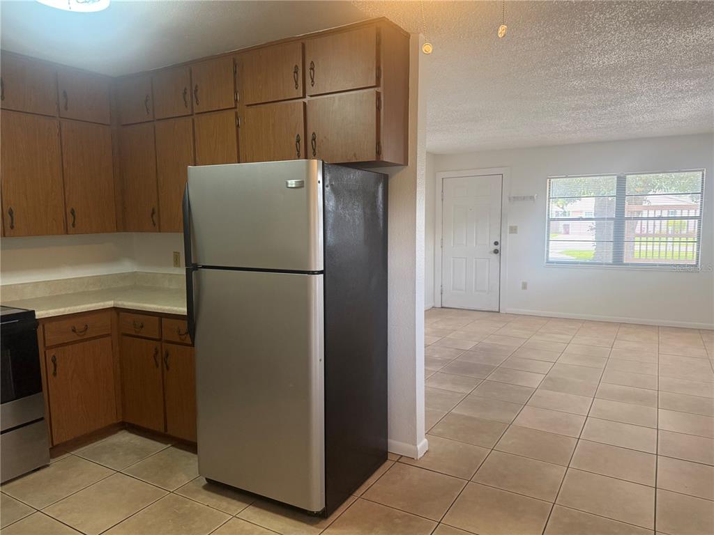 1507 Tennessee Avenue St. Cloud, FL 34769 - Photo 2 of 10 a kitchen with a refrigerator and a stove top oven