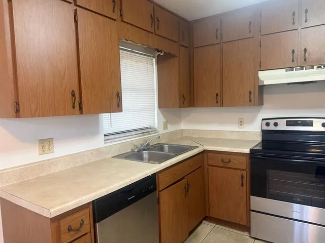 a kitchen with a sink cabinets and a stove top oven