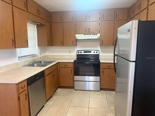 a kitchen with a refrigerator sink stove and cabinets