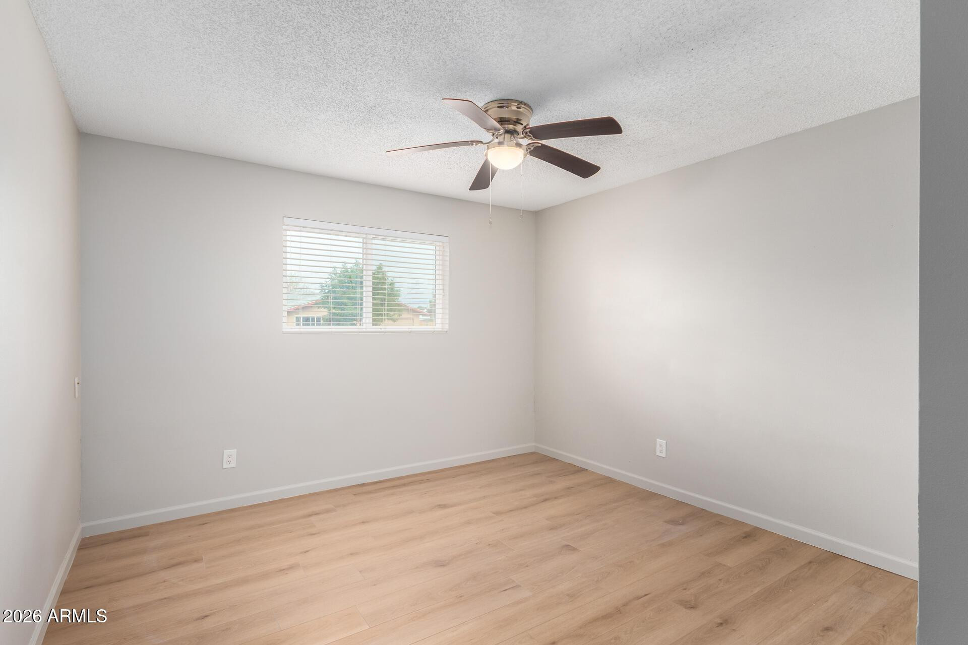 103 East Del Rio Drive Tempe, AZ 85282 - Photo 19 of 28 an empty room with wooden floor fan and windows