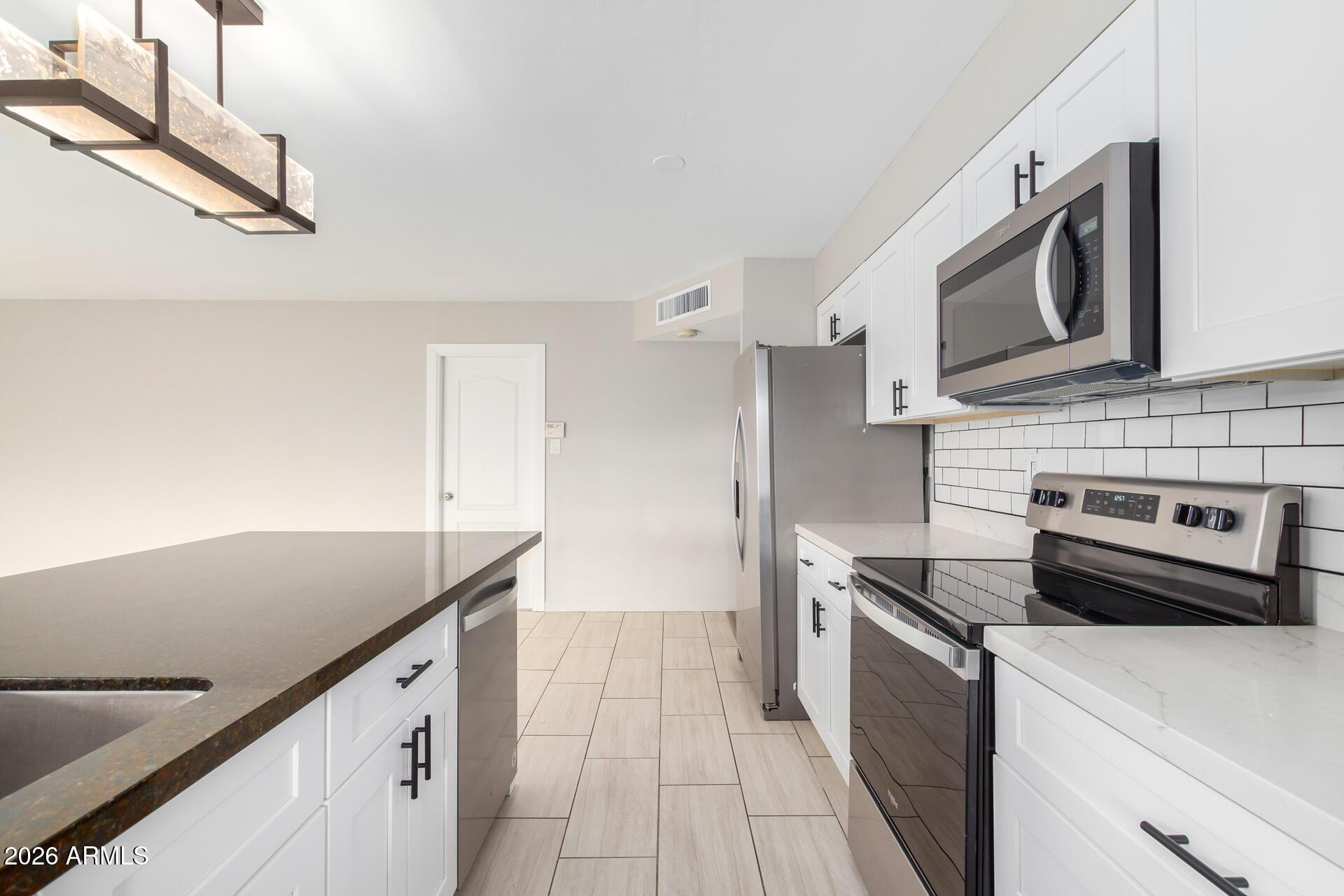 103 East Del Rio Drive Tempe, AZ 85282 - Photo 9 of 28 a kitchen with stainless steel appliances a sink and a stove