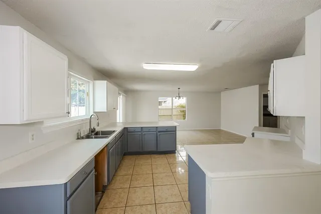 a kitchen with a sink a stove a refrigerator and white cabinets