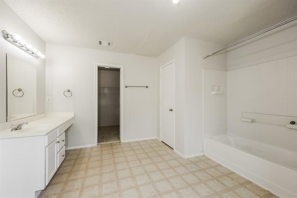 312 Dakota Ridge Drive Fort Worth, TX 76134 - Photo 9 of 15 a bathroom with a sink a mirror and a bathtub