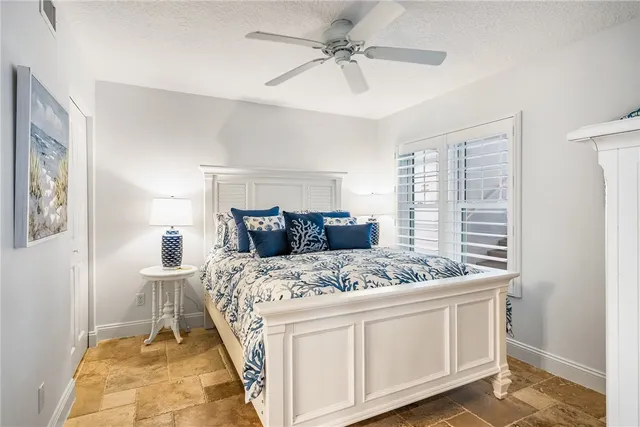 a spacious bedroom with a bed and a chandelier
