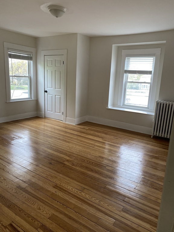 17 Linden Place, Unit 2 Dedham, MA 02026 - Photo 4 of 9 a view of an empty room with wooden floor and a window