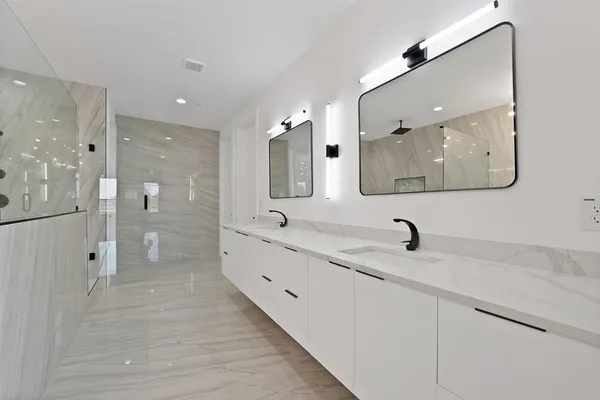 a bathroom with a double vanity sink mirror double and shower
