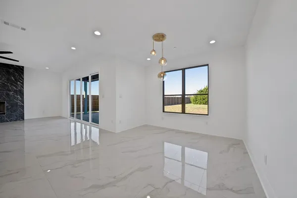 an empty room with windows and ceiling fan
