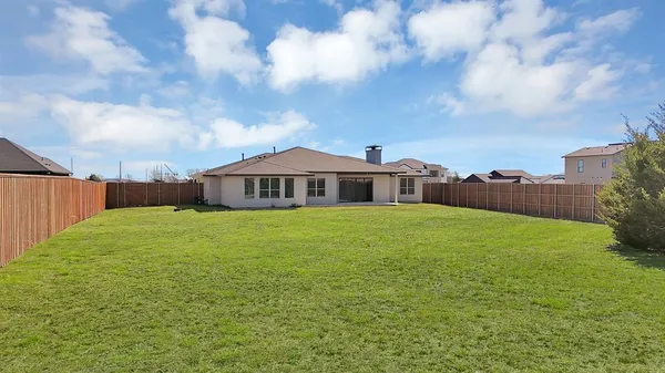 a view of green field with house in background