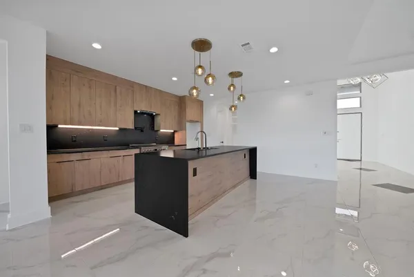 a kitchen with granite countertop a sink cabinets and stainless steel appliances