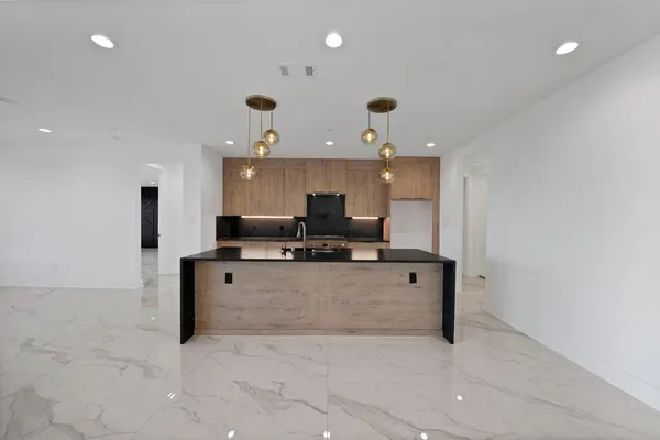 a large white kitchen with a large window a counter space and stainless steel appliances