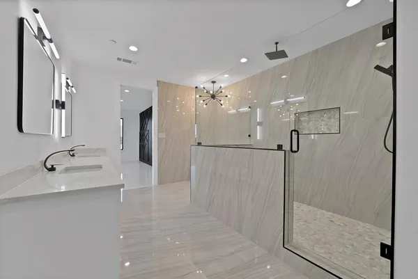 a bathroom with a sink a shower and a mirror