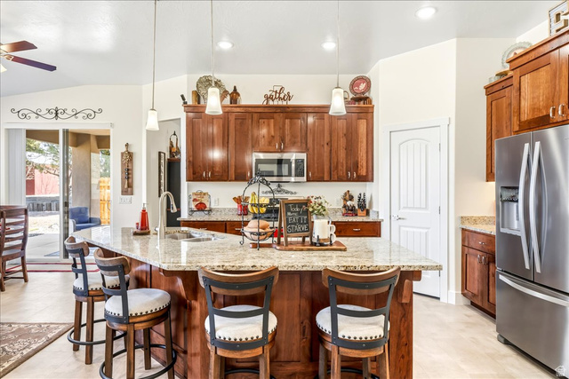 357 East Main Street Enterprise, UT 84725 - Photo 19 of 71 Kitchen with stainless steel appliances, light stone countertops, a kitchen bar, a center island with sink, and ceiling fan