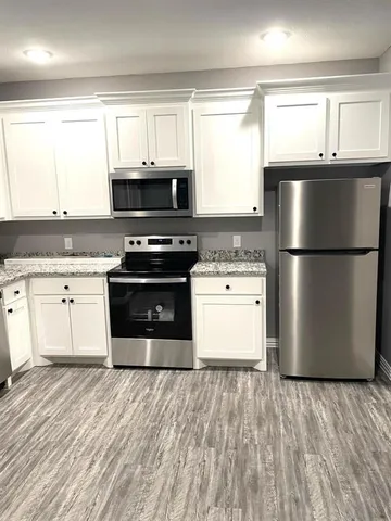 a kitchen with a stove a refrigerator and a sink