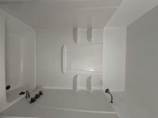 an empty room with a window and a fan