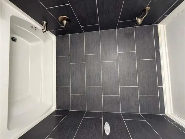a view of wooden floor and a chandelier fan in a room
