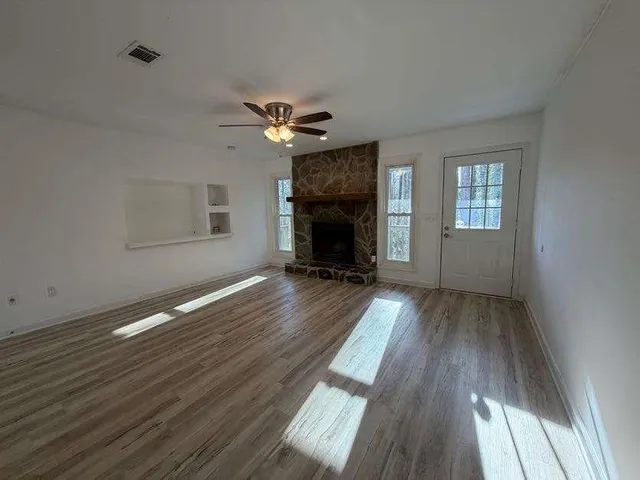 a view of a livingroom with wooden floor and a ceiling fan