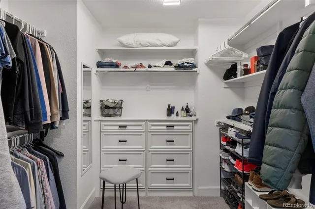 a view of walk in closet with clothes and shoes