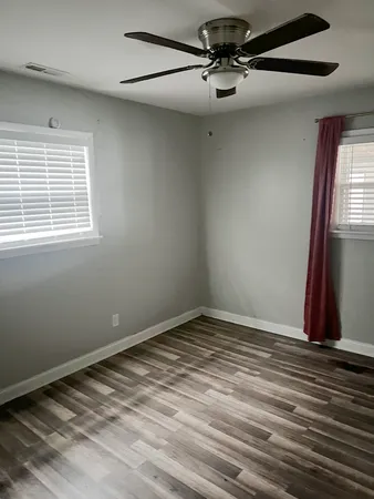a view of an empty room with wooden floor