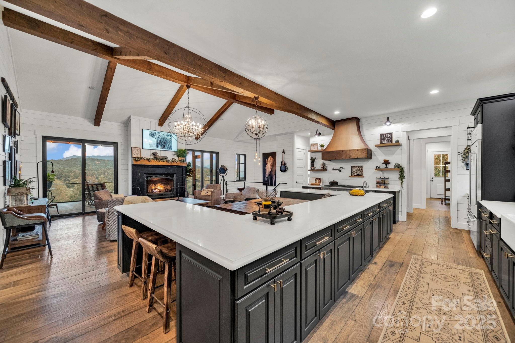 23 Windy Ridge Fairview, NC 28730 - Photo 8 of 47 a kitchen with kitchen island a stove a refrigerator a dining table and chairs with wooden floor