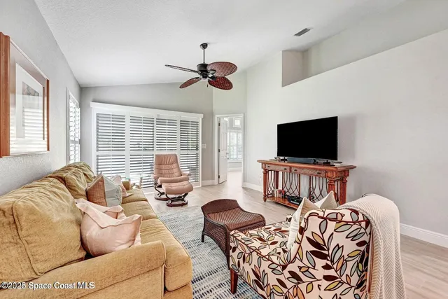 a living room with furniture a flat screen tv and a window