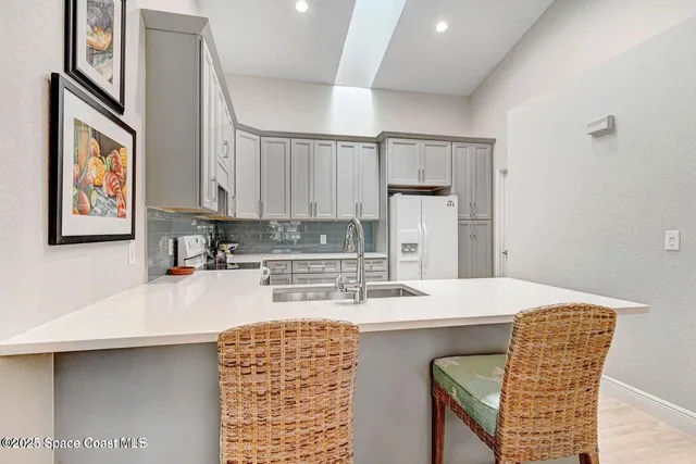 a kitchen with stainless steel appliances kitchen island granite countertop a sink dishwasher and cabinets with wooden floor