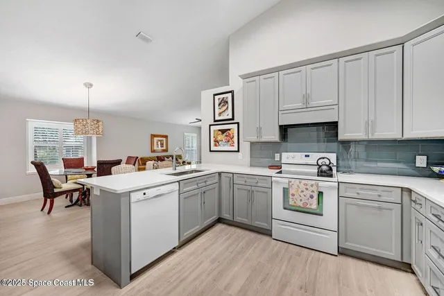 a kitchen with white cabinets and white appliances