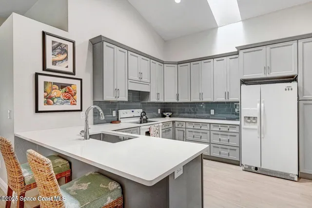 a kitchen with white cabinets and white appliances