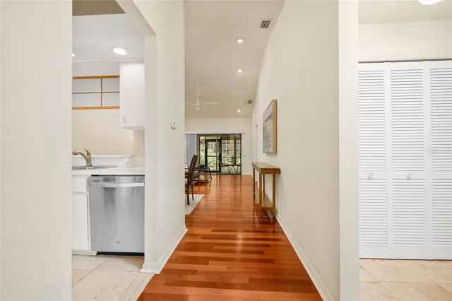 a hallway with white cabinets and wooden floor