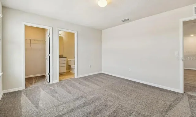 an empty room with closet and a bathroom